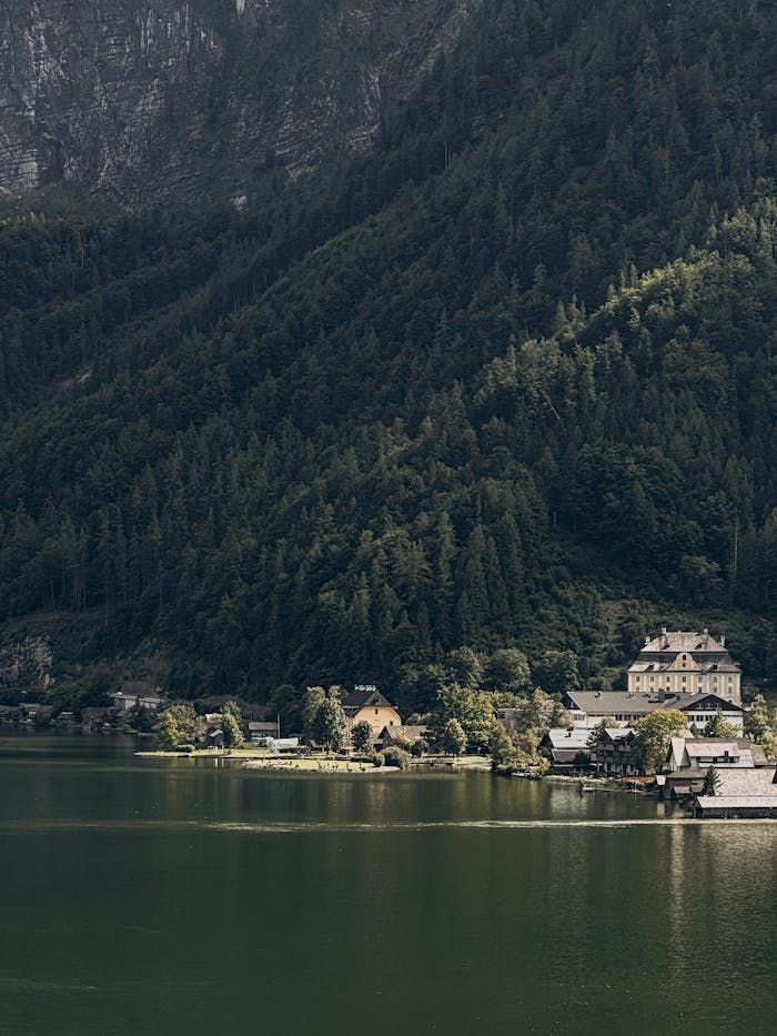 Explore the picturesque Hallstatt village by the serene alpine lake surrounded by lush mountains.